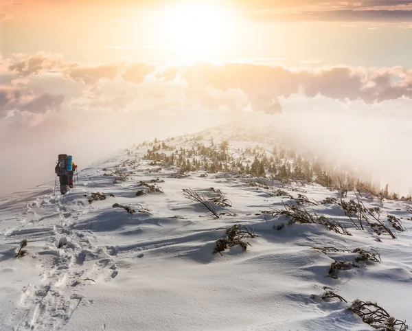 กลุ่มนักปีนเขาในภูเขาฤดูหนาวตอนพระอาทิตย์ตก — ภาพถ่ายสต็อก