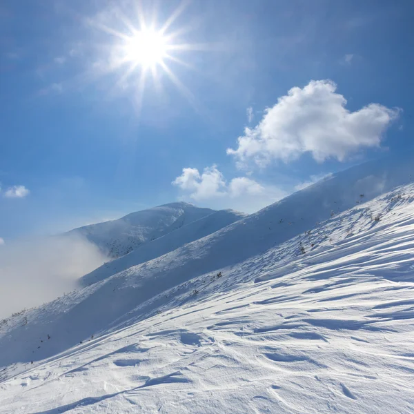 Invierno montañas nevadas bajo un sol brillante —  Fotos de Stock