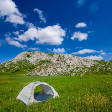 yeşil tepelerin arasında beyaz turistik çadır