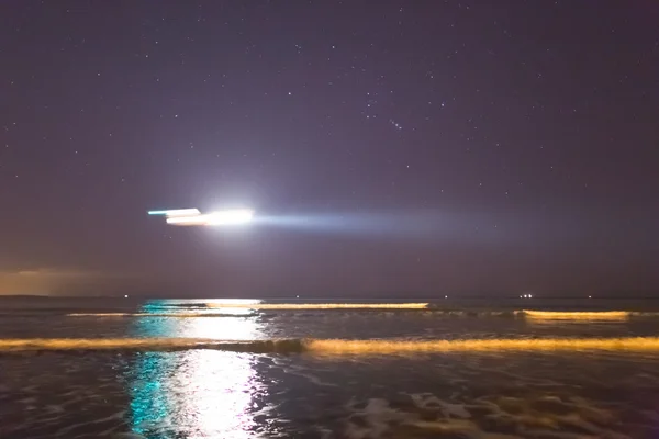 Plane landing above a sea at the night — Stock Photo, Image