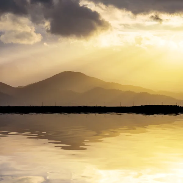 Στους λόφους του ηλιοβασιλέματος που αντανακλάται σε μια λίμνη — Φωτογραφία Αρχείου