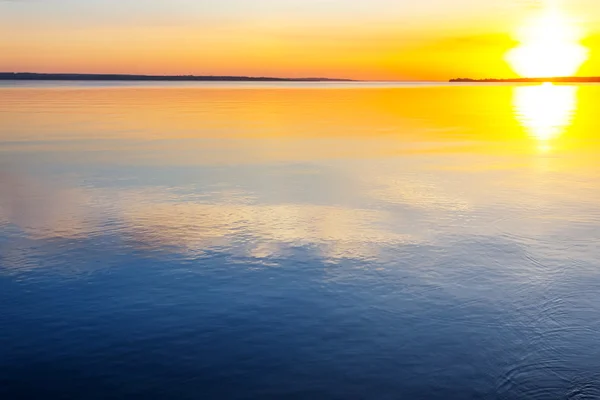 Puesta de sol reflejada en un agua — Stok fotoğraf