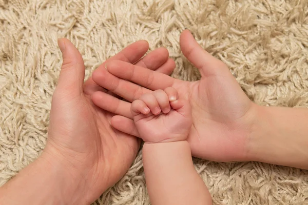 Les parents tiennent la main de l'enfant — Photo