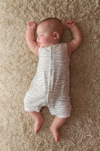 Bebé durmiendo en una alfombra — Foto de Stock