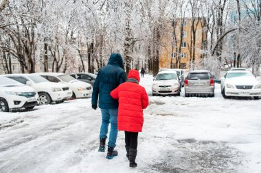Vladivostok, Rusya - 19 Kasım 2020: Kötü karlı havada şehir ve yolların manzarası. Buz, kar ve buz saçaklarıyla kaplı arabalar. İnsanlar kaygan bir yolda sokakta yürürler. Buz fırtınası havası. Kışın şehir.