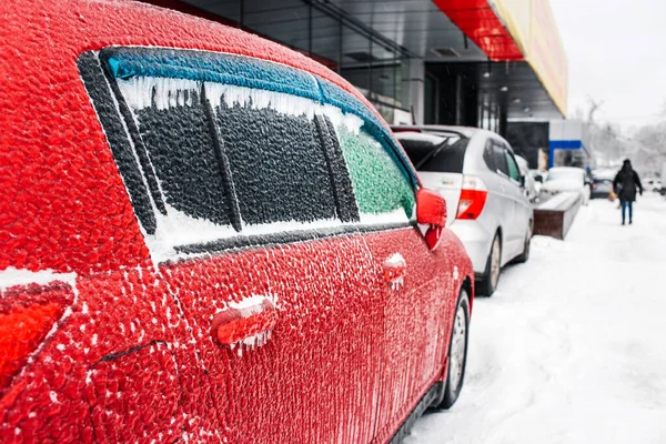 冻雨后 红色的车被冰和冰柱覆盖着 冰封的车窗关上了 11月在俄罗斯符拉迪沃斯托克发生的暴风雪旋风 冬天的城市 下雪的天气 冬季结霜的场面 — 图库照片