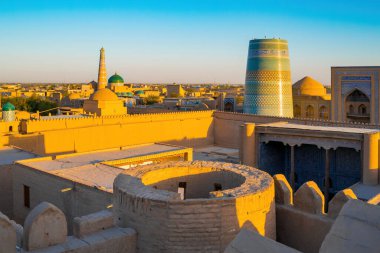 Özbekistan 'ın Khiva kentindeki UNESCO surlu şehri Itchan Kala üzerinde altın gün batımı ışığı