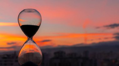 Kum saati ve şehir gün batımında