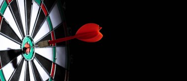 Dart hedefi siyah arkaplanda vurdu.