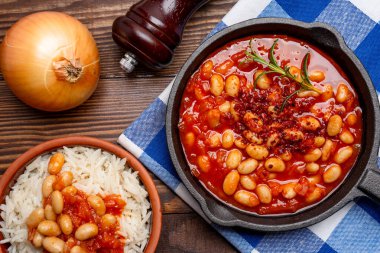 Ahşap zeminde pişirilmiş fasulye kabı dökme demir tavada..