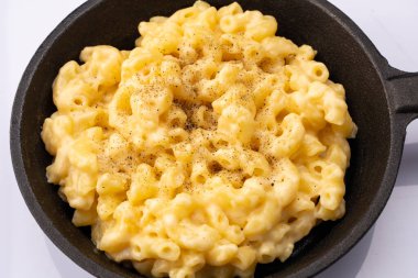 Beyaz arka planda lezzetli peynirli makarna.