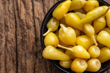 Sarı tombul acı biberler ahşap arka planda turşu