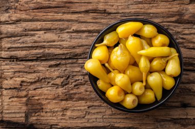 Sarı tombul acı biberler ahşap arka planda turşu