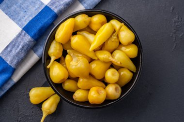 Sarı tombul acı biber siyah taş masa zemininde turşu