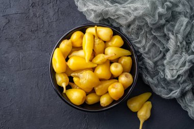 Sarı tombul acı biber siyah taş masa zemininde turşu