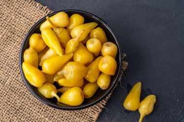 Sarı tombul acı biber siyah taş masa zemininde turşu