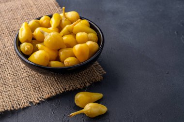 Sarı tombul acı biber siyah taş masa zemininde turşu