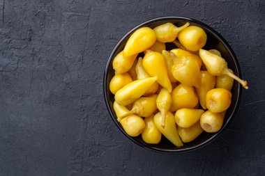 Sarı tombul acı biber siyah taş masa zemininde turşu