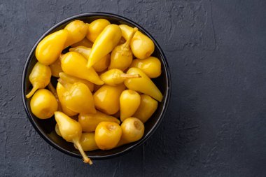 Sarı tombul acı biber siyah taş masa zemininde turşu