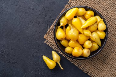 Sarı tombul acı biber siyah taş masa zemininde turşu