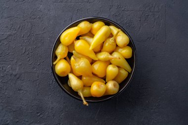 Sarı tombul acı biber siyah taş masa zemininde turşu