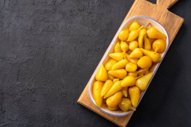 Sarı tombul acı biber siyah taş masa zemininde turşu