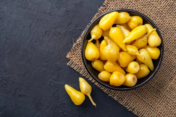 Sarı tombul acı biber siyah taş masa zemininde turşu