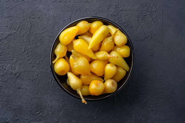 Sarı tombul acı biber siyah taş masa zemininde turşu