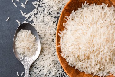 Siyah taş zemin üzerinde çiğ beyaz pirinç yığını