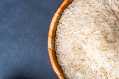 Siyah taş zemin üzerinde çiğ beyaz pirinç yığını