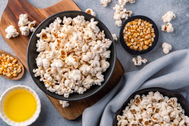 Taş masa arkasındaki kasede nefis patlamış mısır..