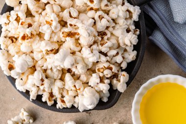 Taş masa arkasındaki tavada lezzetli patlamış mısır..