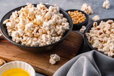 Taş masa arkasındaki kasede nefis patlamış mısır..