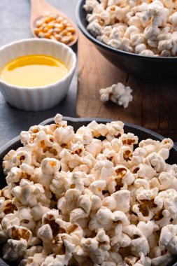 Taş masa arkasındaki kasede nefis patlamış mısır..