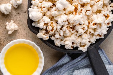 Taş masa arkasındaki tavada lezzetli patlamış mısır..