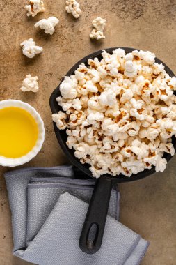 Taş masa arkasındaki tavada lezzetli patlamış mısır..