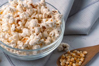 Taş masa arkasındaki kasede nefis patlamış mısır..