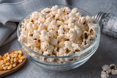 Taş masa arkasındaki kasede nefis patlamış mısır..