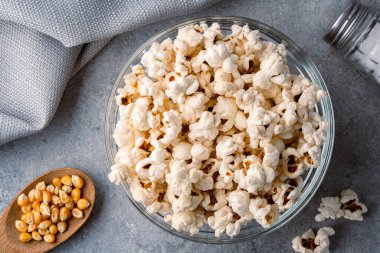 Taş masa arkasındaki kasede nefis patlamış mısır..