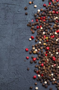 Siyah taş masada karışık biberler.