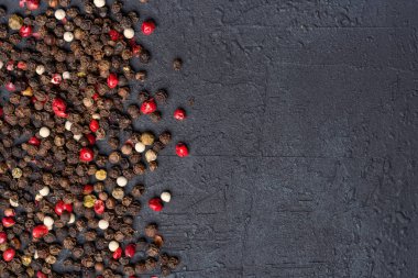 Siyah taş masada karışık biberler.