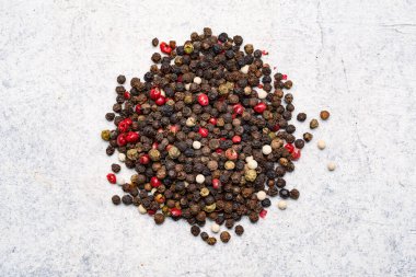 Beyaz taş masada karışık biberler.