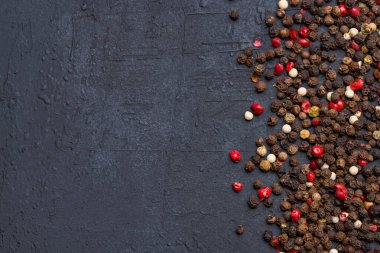 Siyah taş masada karışık biberler.