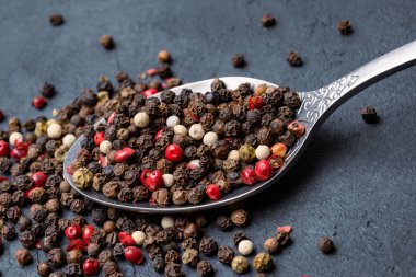 Siyah taş masada karışık biberler.