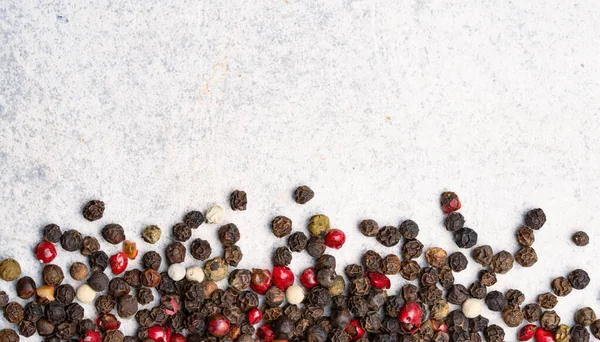 Beyaz taş masada karışık biberler.