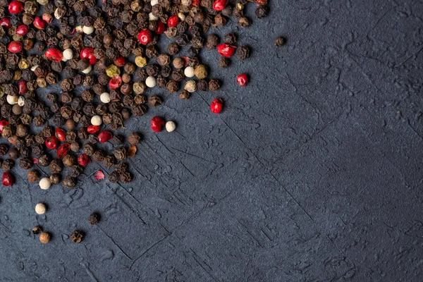 Siyah taş masada karışık biberler.