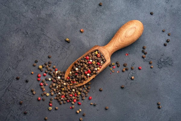 Siyah taş masada karışık biberler.