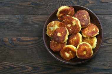 Tahta bir masanın üstünde seramik bir kasede peynirli gözleme. Boşluğu kopyala