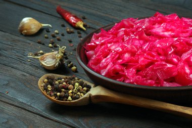 Mayalanmış kırmızı lahana. Ahşap bir masada lahana turşusu ve baharat..