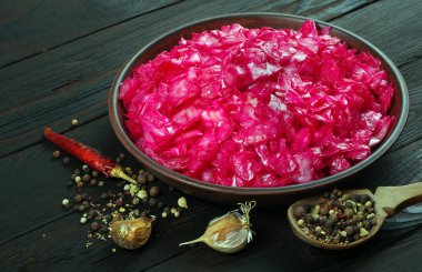 Mayalanmış kırmızı lahana. Ahşap bir masada lahana turşusu ve baharat..